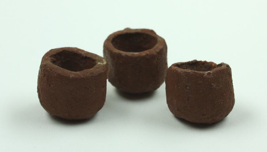 Three clay teacups viewed from side.