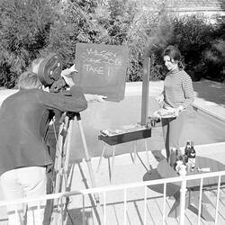 Negative - Camera Operator Filming a Woman Cooking on a Barbeque, Victoria, 1970