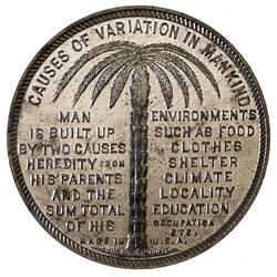Round medal with tree fern and text.