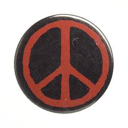 Black round badge with red peace symbol.