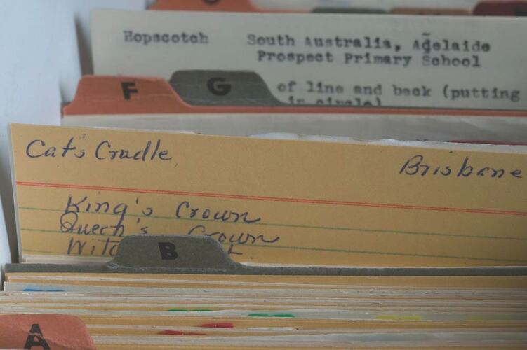 Different coloured index cards with handwritten and typewritten text.