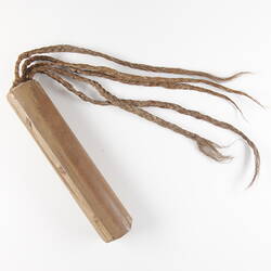 Wooden doll made of stick and plaitted material representing hair.