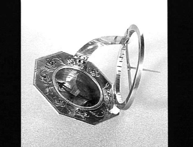 Black and white image of metal round sundial.