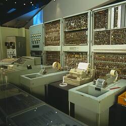 Large computer, tape readers, circuitry cabinets on display.