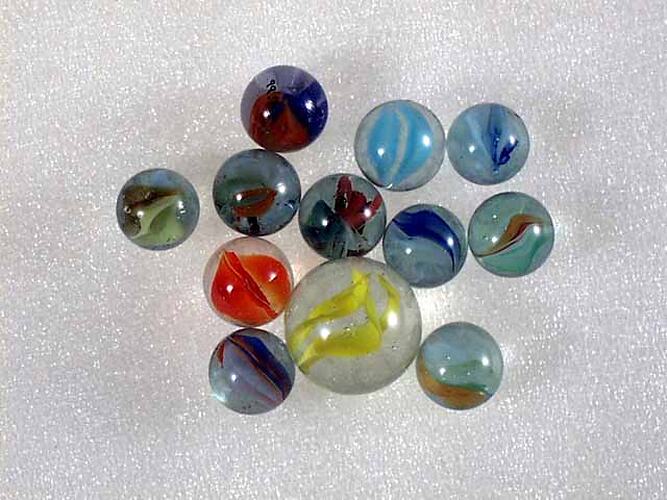Coloured glass marbles on stippled surface.