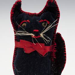 Navy blue velvet cat with red stitched edging and string whiskers.