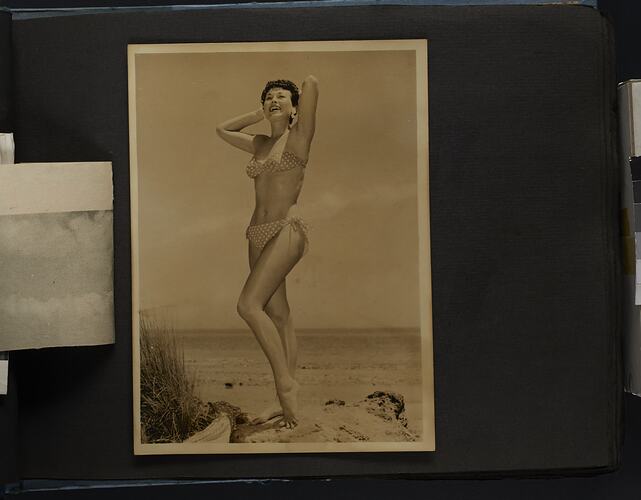 Album page, photograph, black and white, woman posing in polka dot bikini, standing.