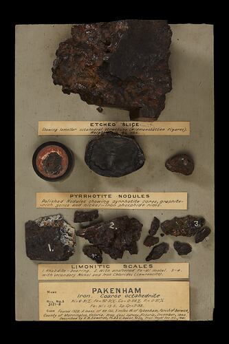 Board with pieces of rock and text mounted to it.