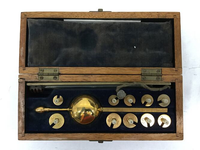Wooden lined case with brass measuring weights.