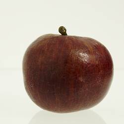 Wax apple model painted dark red with brown stem.