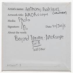 Label on back of white canvas with printed and handwritten text.