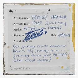 Label on back of white canvas with printed and handwritten text.
