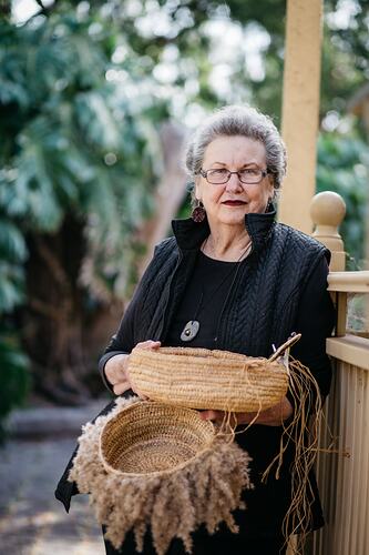 Aunty Jennine Armistead Holds Weaved Baskets