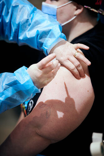 Staff member giving Vaccination, St Vincent's Vaccination Hub, Melbourne Museum, 23 Sep 2021