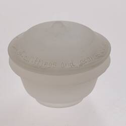 Opaque glass round spice container with lid. Narrower at base.