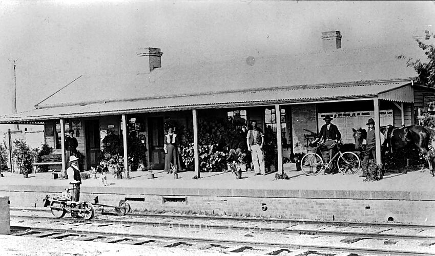 [Gangers' trolley at Tourello Railway Station with railway staff and passengers standing at platform, 1908.]