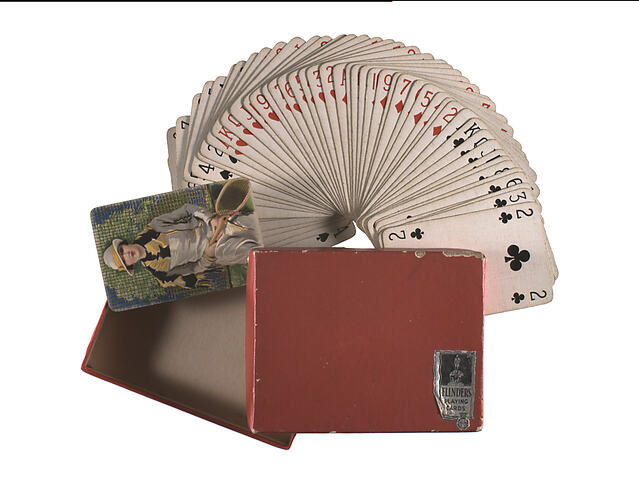 Pack of cards fanned out next to box.