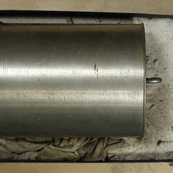 Silver cylindrical section from a clock.