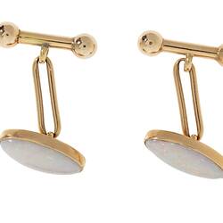 Gold clip cufflinks, each with an oval white opal.