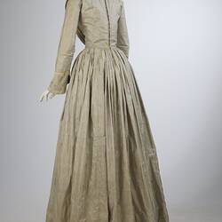 Pale grey striped silk dress with long sleeves and long skirt. Back view.