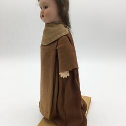 A doll dressed as a friar in brown robes