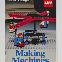 Front cover with LEGO build. Four red carousel-like arms hold LEGO figures, grey base. Text above and below.