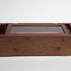 Wooden rectangular box. Glass section on top on box.