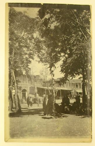 Village scene with people, trees & buildings,