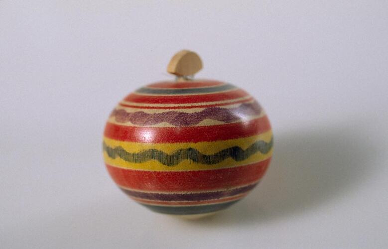 Side view of spinning top with coloured stripes.