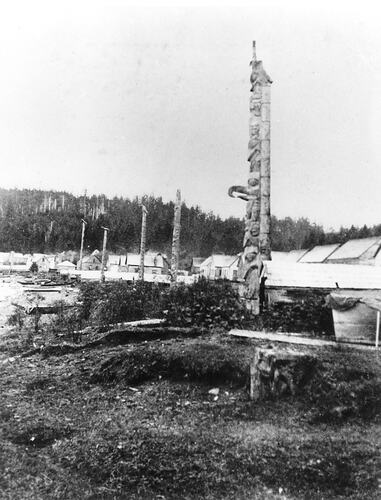 Grainy photograph of totem poles.