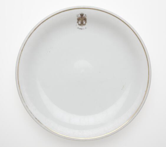 White plate with rim and crest.