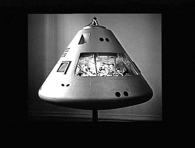 Conical shaped space module with strip window across middle.