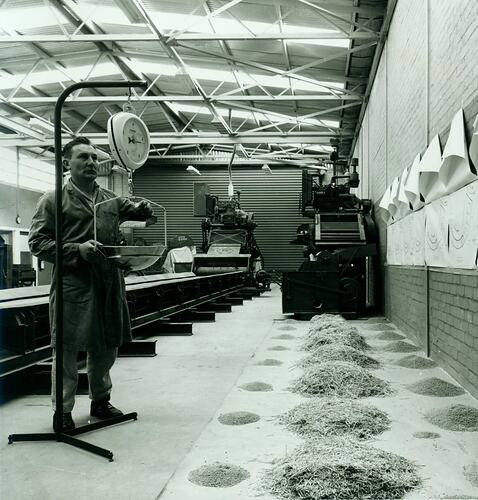 Man weighing grain next to test machine.