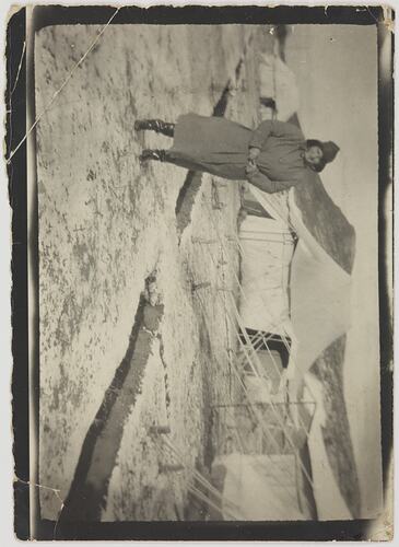Woman in cold weather clothing standing on snowy ground next to tents.