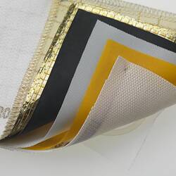 Rectangular fabric sample with six layers. White, gold, black, white, yellow, white. Detail.