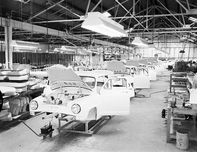 Monochrome photograph of a vehicle manufacturing plant.