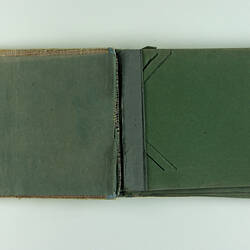 Inside pages of postcard album emptied of postcards.