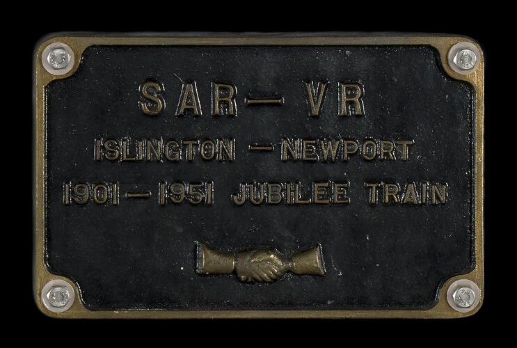 Rectangular black plate with gold lettering and border.