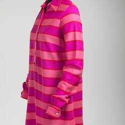 Left side of pink striped mini polo-shirt dress. Long sleeve with collar, cuffs, front buttons.