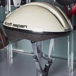 White bicycle helmet with grey padding and strap.