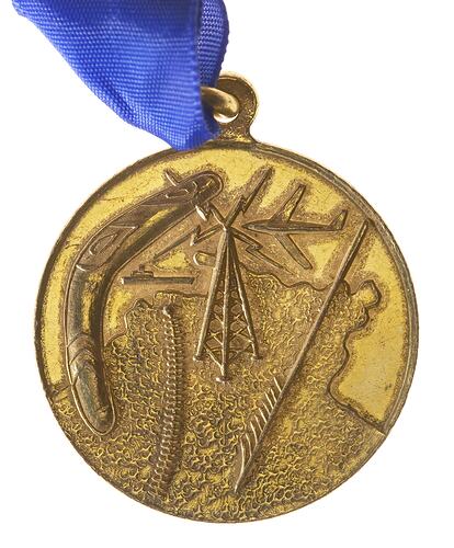 Round medal, Northern Territory map under a boomerang, ship, railway, radio transmitter, spear.