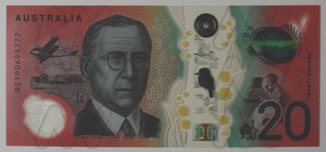 Orange polymer Australian 20 dollar note with man on left and birds and plants on right.