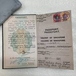 Open passport with white pages. Green yellow pattern on left and postage stamps on right.