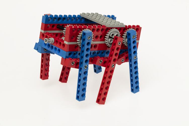 Red, blue and grey LEGO robot with three legs either side.