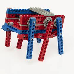 Red, blue and grey LEGO robot with three legs either side.