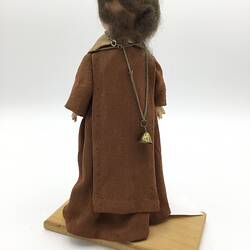 A doll dressed as a friar in brown robes