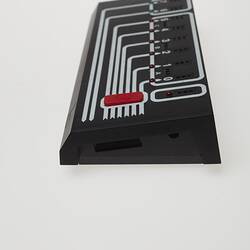 Left side of rectangular black plastic computer control. White lines and lights on top.