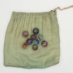 Coloured glass marbles on cloth bag.