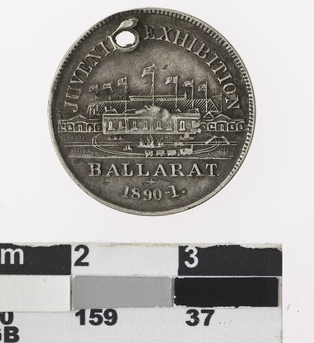 Round medal with building and text.