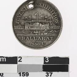 Round medal with building and text.